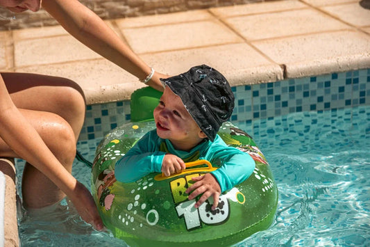 bébé dans une piscine avec une bouée verte