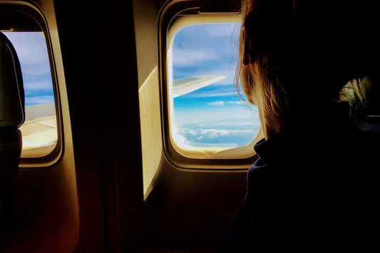 femme qui regarde à travers une fenêtre d'avion