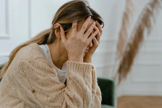 femme stressée qui a ses mains sur son visage