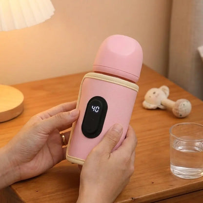 Chauffe biberon nomad Nido rose pivoine porté par des mains fines avec table de nuit et verre d'eau en arrière plan