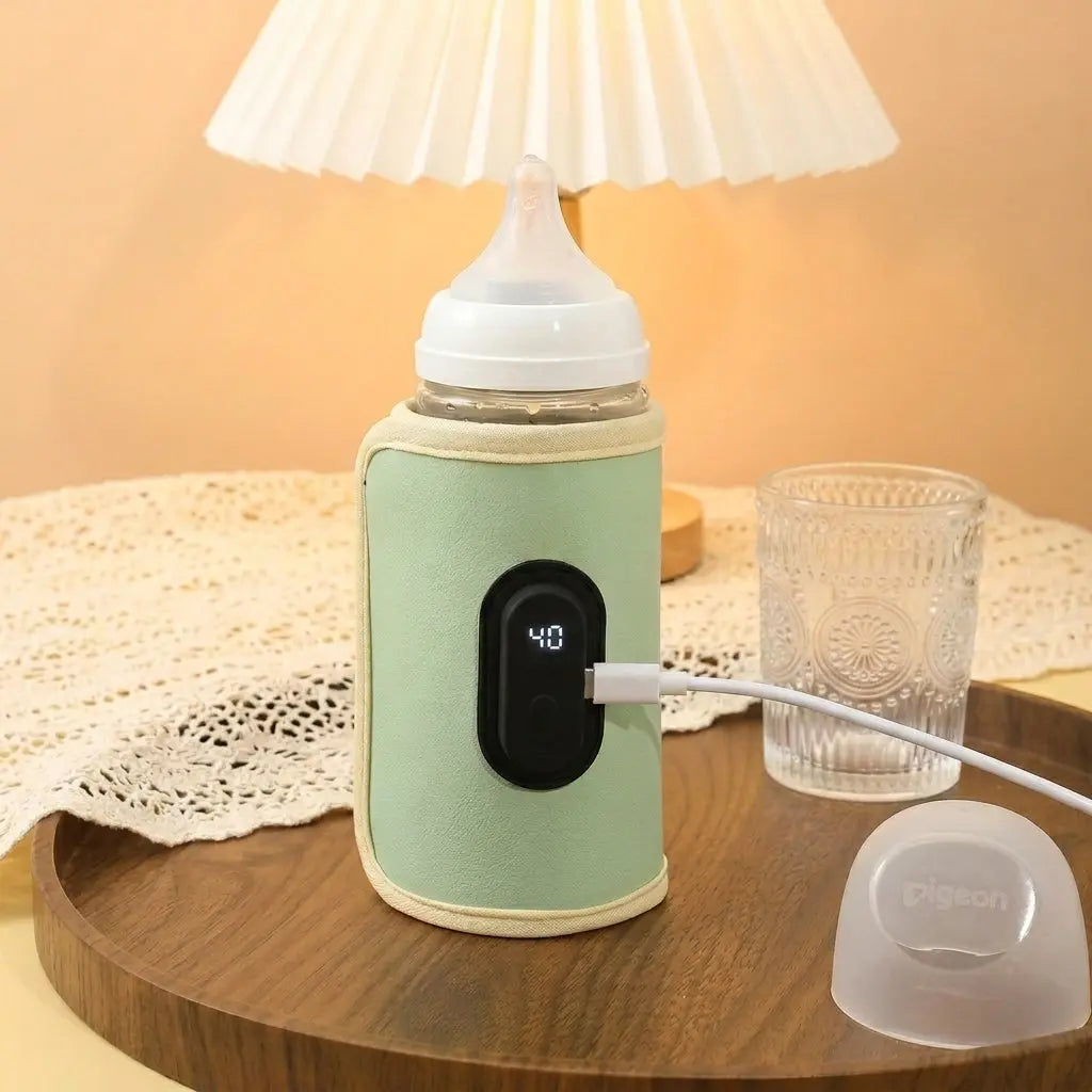 Chauffe biberon nomad Nido vert sauge posé sur table de nuit